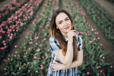 美丽的美丽快乐的女士在一片粉红色郁金香图片