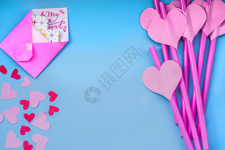 粉红色背景上的粉红色纸心吸管五颜六色的明亮派对啜图片