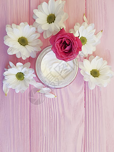粉红色木质玫瑰上的奶油化妆品白花图片