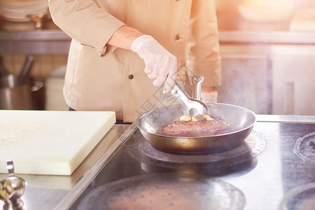 大蒜烤肉男厨师在专业厨房煎鸭的手餐厅的人做美味的肉类饭图片