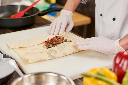 厨师烹饪墨西哥卷饼厨师手包裹玉米煎饼填充玉米煎饼在厨房准备墨西图片