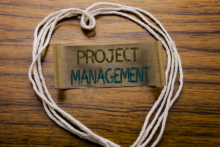 十大项目管理表概念手写文本标题项目管理战略计划目标的商业概念写在深色木质背景的便条纸上用心背景