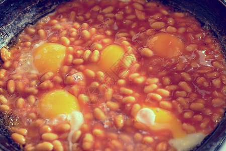早餐单身汉炸鸡蛋特写着豆子在煎锅上加了肉汤营养烹饪和单图片