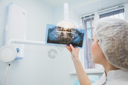 女医生牙医检查人类颌骨的X射线专业口腔科医生在诊所办公室检查牙科图片
