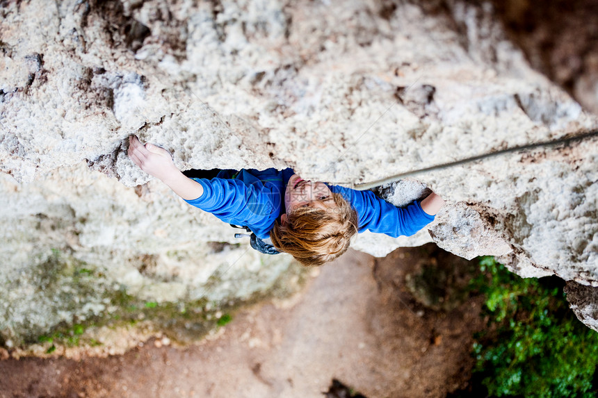 一个情绪激动的男孩爬上岩石孩子在天然浮雕上进行攀岩运动的孩子积极地花时间在新鲜空气中锻图片