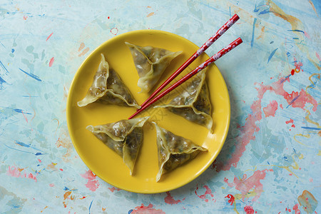 美味的东方点心饺子特写用筷子图片