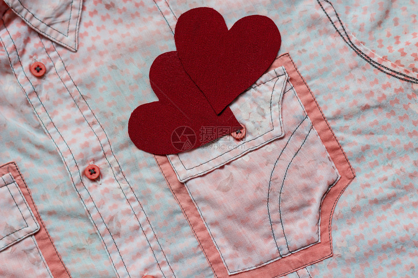粉红色衬衫口袋背景上的两颗红心图片