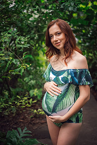 很快成为长发红的妈穿着花草泳衣带着双手围着肚子在绿化的地方做美貌图片