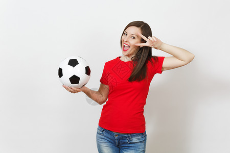 漂亮的欧洲年轻女子足球迷或穿着红色制服的球员拿着经典足球图片