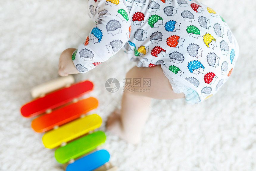 可爱漂亮的小女婴在家里或托儿所玩教育木制玩具蹒跚学步的孩子与五颜六色的堆栈音乐玩具快乐健康的孩子图片