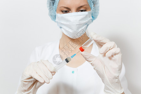 戴面罩戴无菌帽戴手套的女医生用注射器从瓶子里抽出液体药物图片