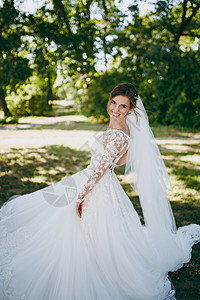 微笑的新娘穿着白色蕾丝连衣裙图片