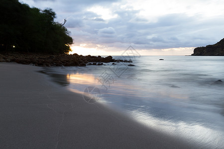 速来抢购尼加拉瓜海滩上美丽的日落以缓慢的百叶速来模糊海浪运动并照亮黑暗背景