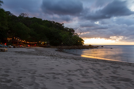 速来抢购尼加拉瓜海滩上美丽的日落以缓慢的百叶速来模糊海浪运动并照亮黑暗背景