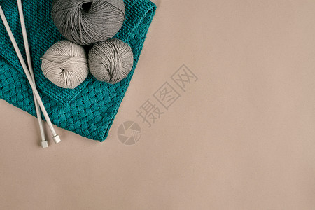 绞纱米色背景上的灰色和绿松石针织羊毛和织针织作为一种针线活五颜六色的毛线球和织针顶视图静物复背景