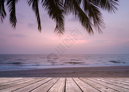 日落或日出时椰子棕榈在热带岛屿海滩图片