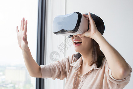 亚洲女佩戴VR耳机享受体验图片