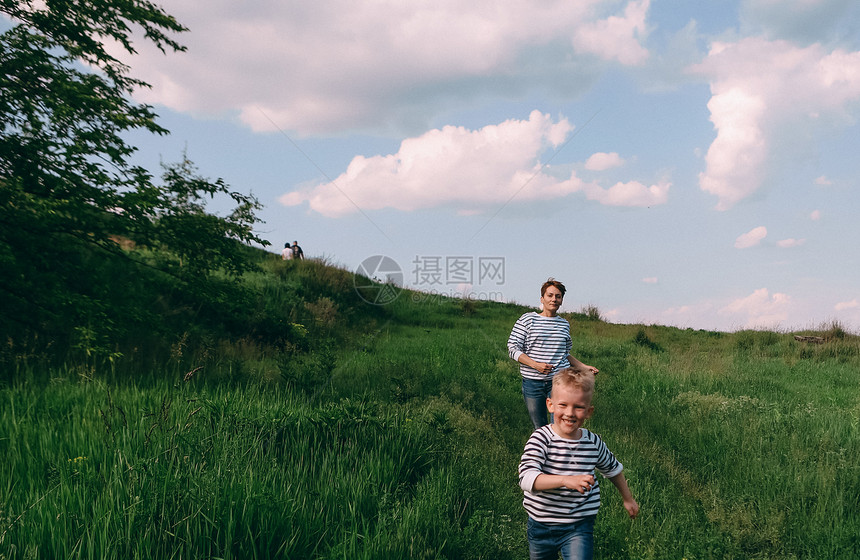 妈在田野路上追着他儿子跑全家看着牛图片