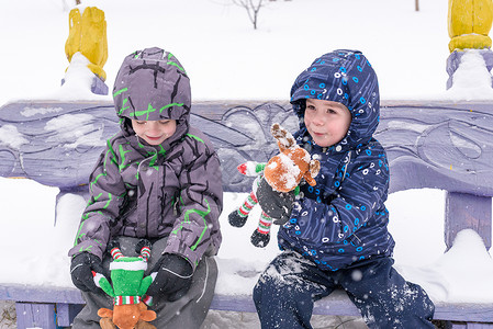 两个可爱的学龄前孩子冬天的兄弟男孩穿着假雪和图片