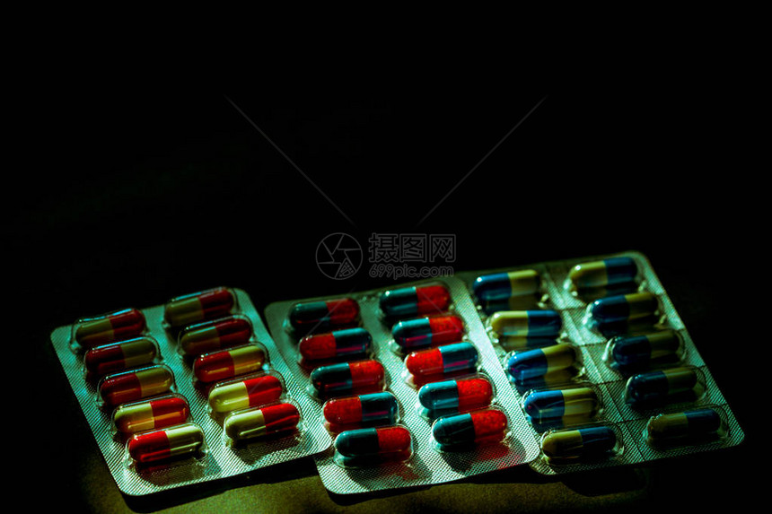 五颜六色的抗生素胶囊丸在泡罩包装在黑暗的背景与复制空间感染疾病的药物合理使用抗生素药物耐药和图片
