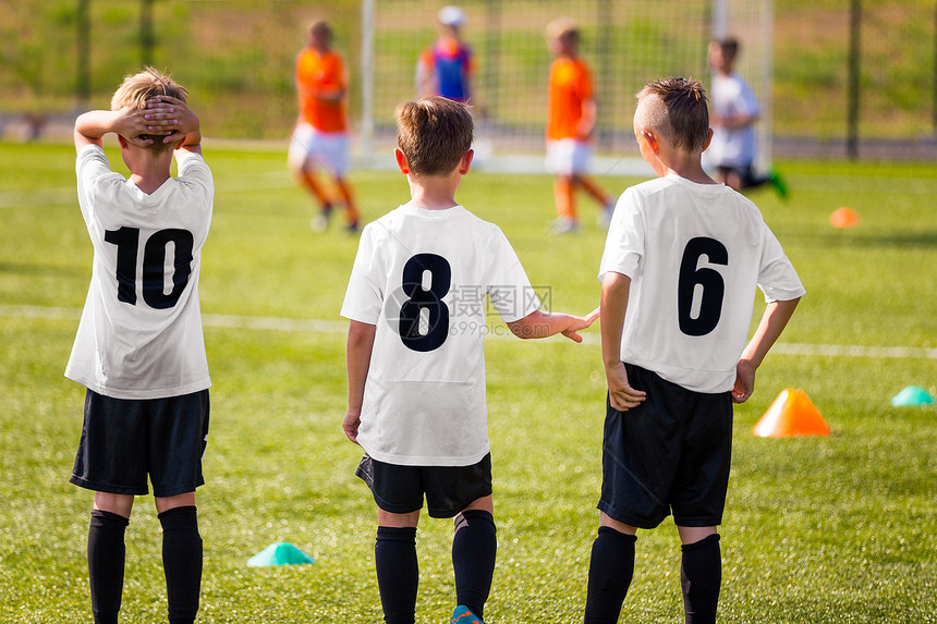 儿童足球队观看足球比赛的年轻男孩背景中的足球锦标赛比KidsFootball球员图片