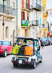 意大利西里岛巴勒地区Cefallu老城街上装有行李袋的高图片