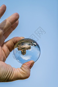 中世纪波尔科夫城堡废墟的反射一个水晶清晰的圆玻璃球把我的人握图片