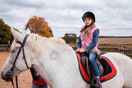 小女孩在农场骑马的照片图片