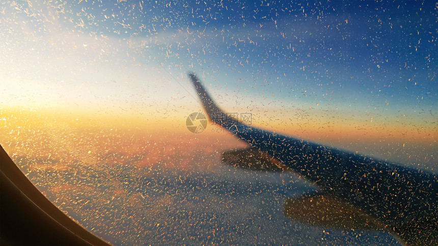 飞机行期间飞机窗口上雪花的图片