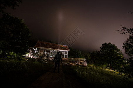 夜间绿草大树和废弃房屋背景图片