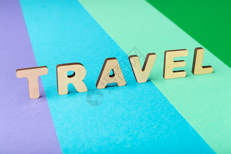旅行用木字母拼写在多彩背景上旅程假期和假日概图片