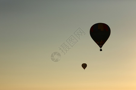 热气球大气层的芭蕾舞团在日出时飞背景图片