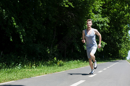 早上运动时在公园跑步机上慢跑的年轻运动图片