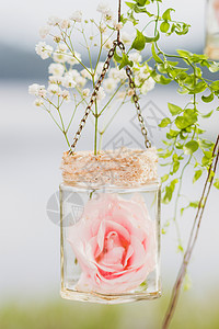 婚纱装饰穿着透明的吊瓶白花和粉红色花图片