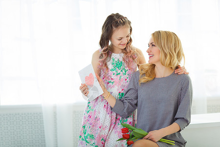 女儿给了她母亲一束郁金香花和一张用她亲手图片
