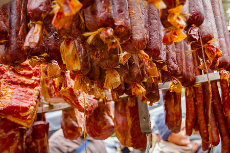 腌肉和香肠挂在户外跳蚤市场出售背景图片