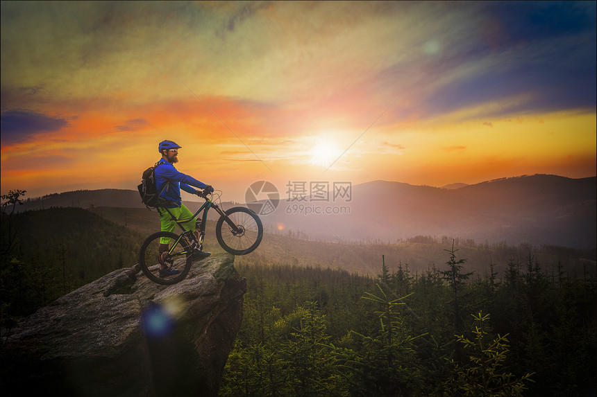 山地车手在日落时骑自行车在夏季山林景观中男子骑自行车MTB流径赛道图片