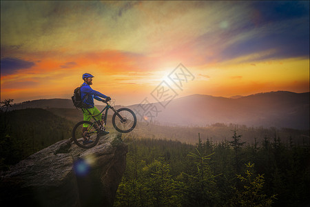 山地车手在日落时骑自行车在夏季山林景观中男子骑自行车MTB流径赛道图片