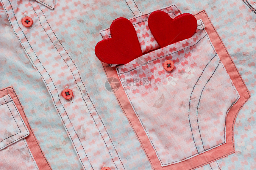 粉红色衬衫口袋背景上的两颗红心图片