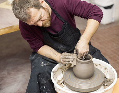 观看艺术家在旋转轮上制作粘土陶器图片
