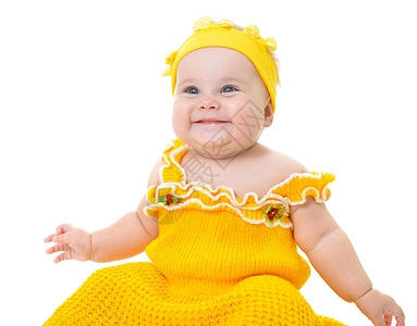 可爱的女婴在工作室里穿着黄色连衣裙摆姿势图片