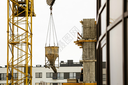 起重机抬起水泥桶在建筑工地运输新楼摩天图片