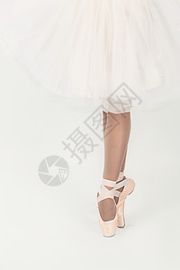 芭蕾舞女演员的腿和白色背景上的白色连衣裙图片