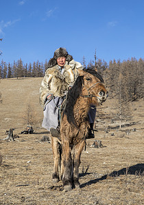 蒙古男子身着狼皮夹克骑在北蒙古高清图片