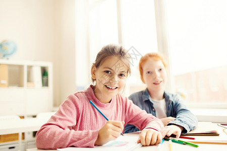 快乐的小女孩用蜡笔画和她的学校图片