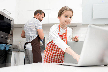 在厨房用笔记本电脑和爸一起做饭时图片