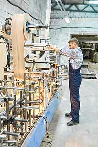 在现代车间的机器上放置木板的成熟工厂人全长图片