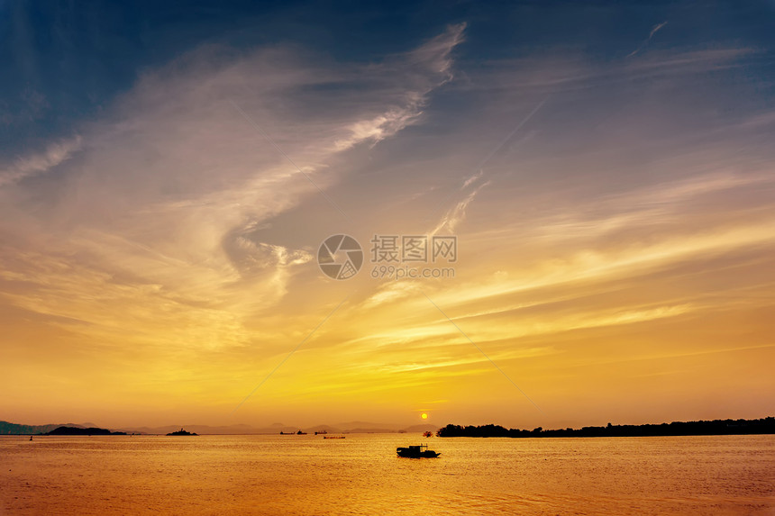 日落时海上渔船的剪影图片
