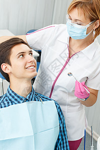 女牙医和牙医办公室的年轻人英俊的年轻人正在牙科诊图片