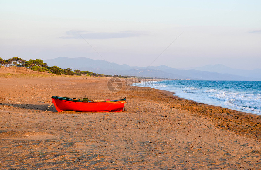 日落时分希腊凯法斯荒凉沙滩上的小船图片